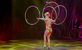 A woman juggles hoops.