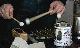 A close-up on a pair of hands playing the xylophone.